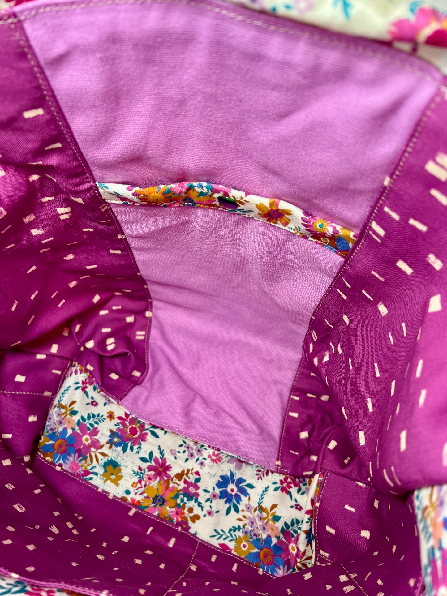 Close-up of a tote interior showing a deep snap pocket.  