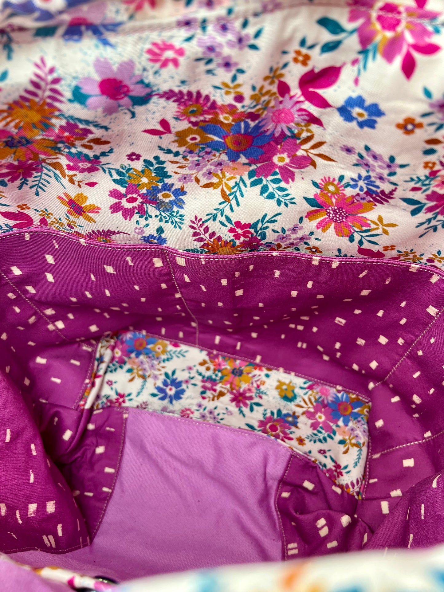 Close-up of a tote interior showing roomy slip pockets in a floral print.