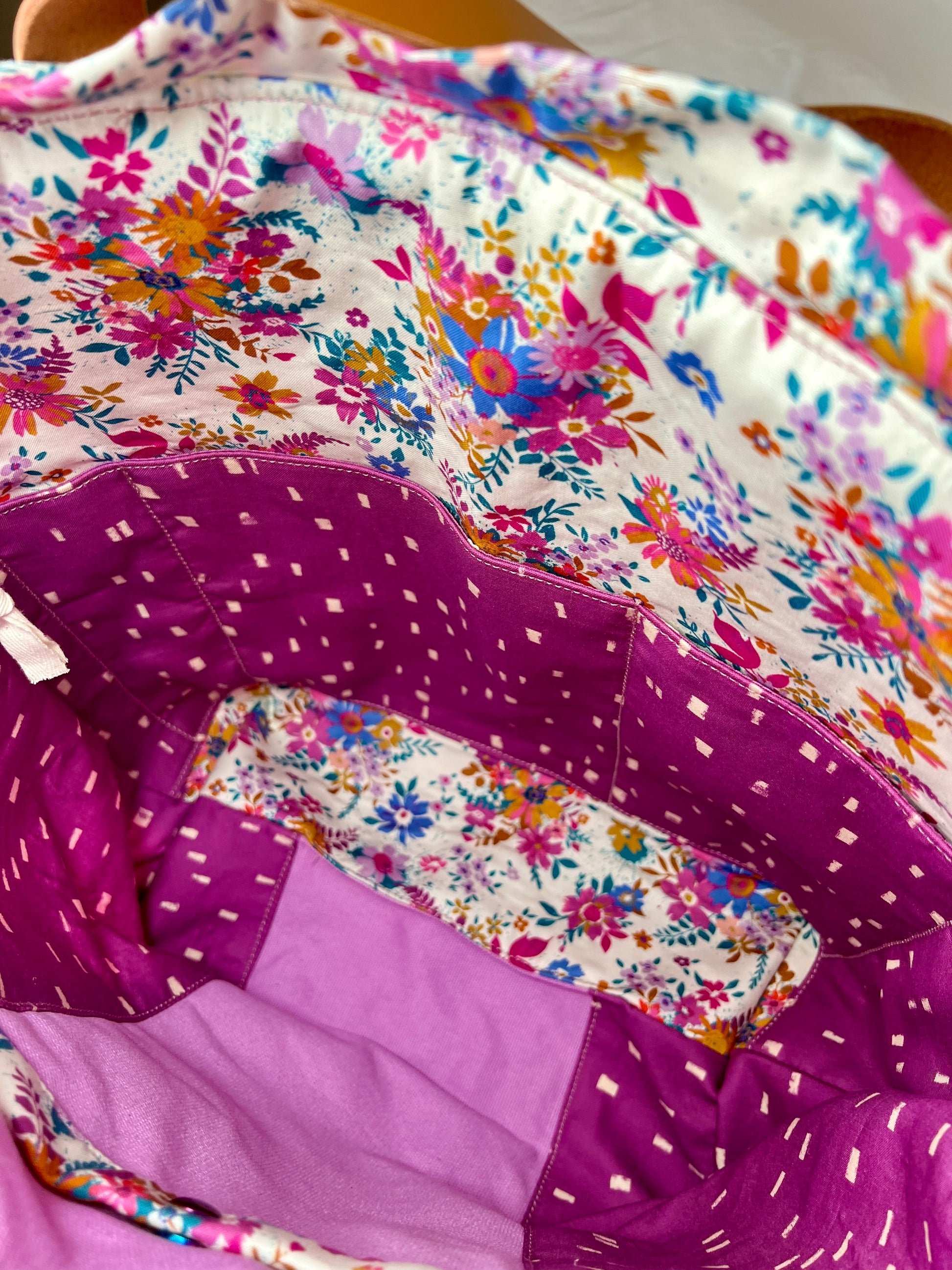 Close-up of a interior of the bag, showing a colorful floral print and two generous slip pockets.