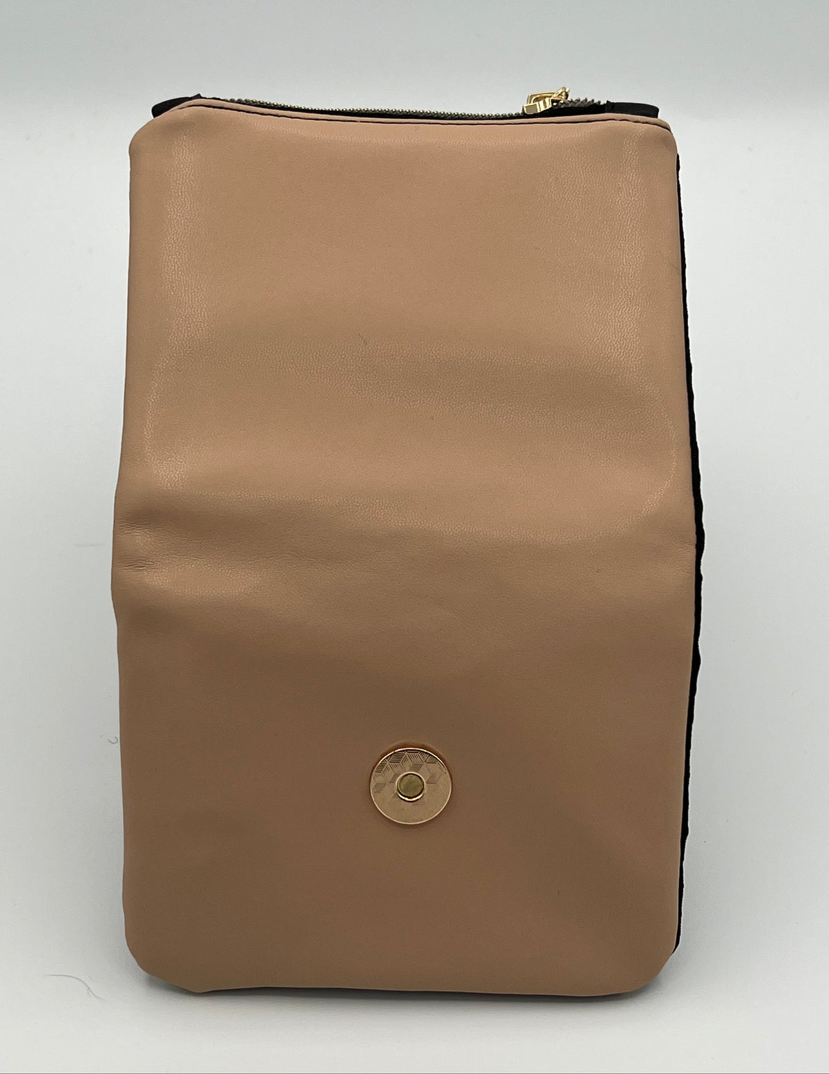 A blush pink faux-leather zippered wallet with a gold-tone circular snap button on the front, photographed against a light gray background.