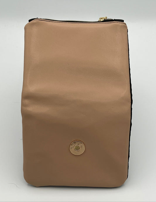 A blush pink faux-leather zippered wallet with a gold-tone circular snap button on the front, photographed against a light gray background.